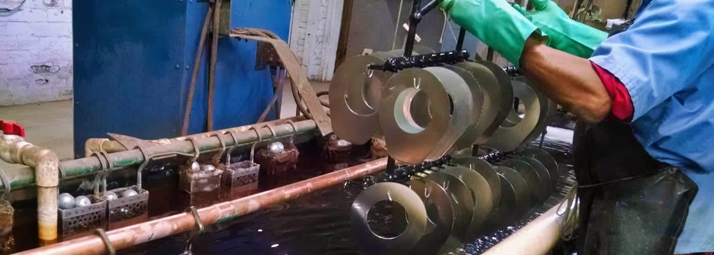 A Parker Metal Finishing plater running zinc parts by hand at the plating line